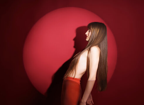 Woman in red with distinctive shadow on red background