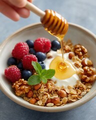 Yogurt with berries, granola, nuts, and honey drizzle