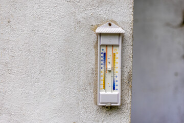 Außenthermometer hängt an einer Hauswand