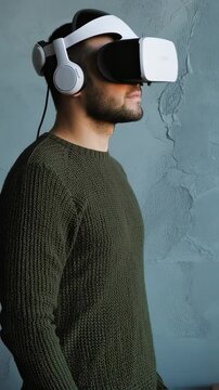 Focused man using white VR headset in neutral space vertical video