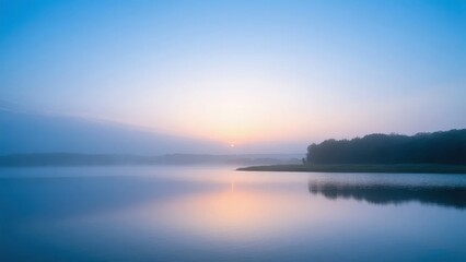 Obraz premium Sunrise over a tranquil lake with mist on the water and trees in the background