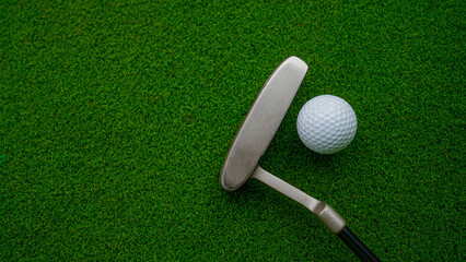 Golf clubs and balls on a green lawn in a beautiful golf course with morning sunshine.