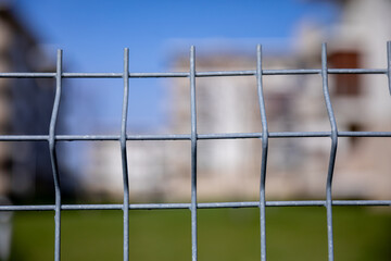 A CloseUp View of a Wire Mesh Fence Framed by a Beautifully Blurred Background Scene