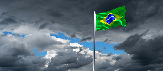 dramatic sky with national flag of Brazil in strong wind