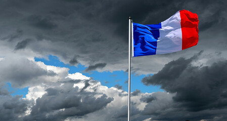 dramatic sky with national flag of France in strong wind