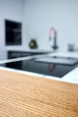 Solid ash glued timber under varnish edge corner table top selective focus macro closeup. Kitchen interior contemporary design countertop tabletop.
