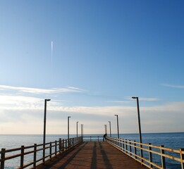 Obraz premium Lonely pier stretching into the sea under clear sky