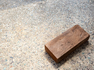 Wooden Block Resting on a Textured Stone Surface with Natural Light
