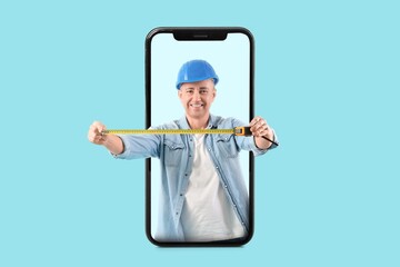 Male construction worker with tape measure popping out of phone screen on light blue background