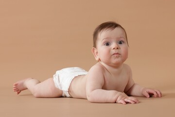 Cute little baby crawling on beige background