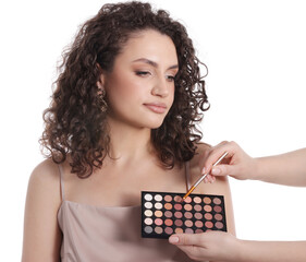 Makeup artist applying eyeshadows onto woman's face on white background, closeup