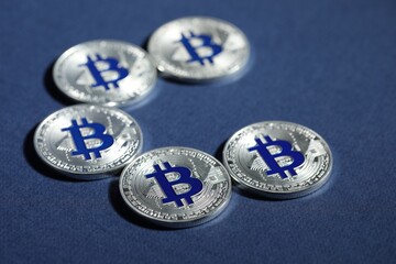Cryptocurrency. Silver bitcoins on dark blue background, closeup