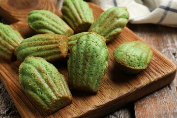 Tasty matcha madeleine cakes on wooden table, closeup