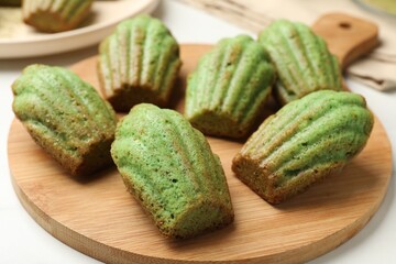 Tasty matcha madeleine cakes on white table, closeup