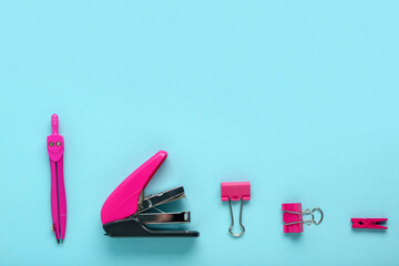 Compass, stapler and clips on blue background