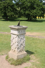 A Classic Sundial on a Stone Plinth in a Country Park.