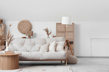 Interior of light living room with sofa, table and pampas grass