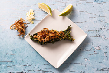 Lebanese hindbeh with caramelized onions and lemon slice on plate.