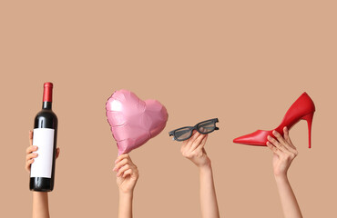 Female hands with 3D glasses, bottle of wine, heeled shoe and air balloon in shape of heart on...