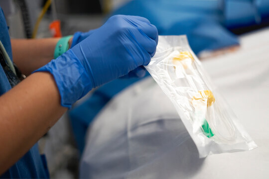 Nurse opening sterile package containing iv catheter in hospital setting
