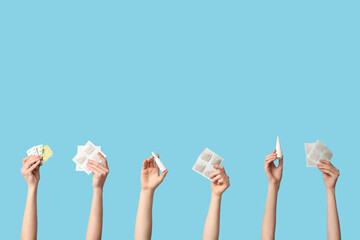 Female hands holding mustard plasters, nasal sprays and pills on blue background