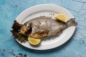grilled fish, whole fish, seafood, lemon, sea bream, dorado, food photography, rustic, gourmet, plate, lettuce, Mediterranean, fish dish, ocean theme, cooked fish, fresh, herbs, roasted, main course, 