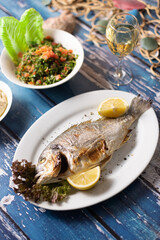Lebanese seafood and mezza spread styled over rustic blue table.