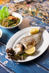 Lebanese seafood and mezza spread styled over rustic blue table.