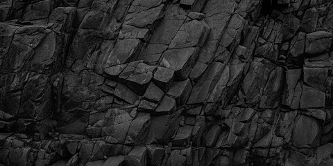 Dark textured rock face shows abstract and jagged geometric patterns across the rough surface