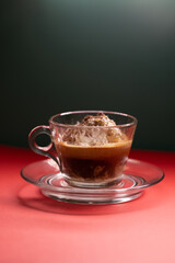Affogato served in glass cup with whipped cream and espresso.