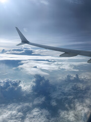 Fototapeta premium Airplane wing flying above white clouds during daytime