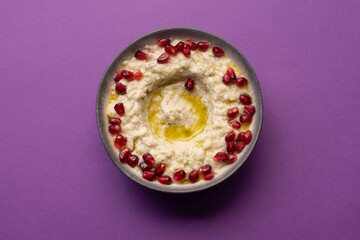 Creamy baba ghanoush topped with pomegranate seeds and olive oil.

