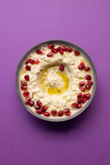 Creamy baba ghanoush topped with pomegranate seeds and olive oil.
