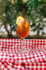 Aperol spritz served chilled with orange slice, outdoor setting.