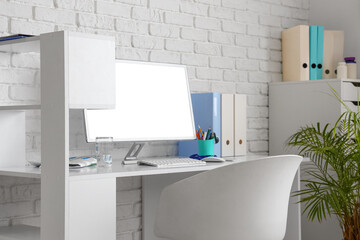 Doctor's workplace with computer and folders in medical office