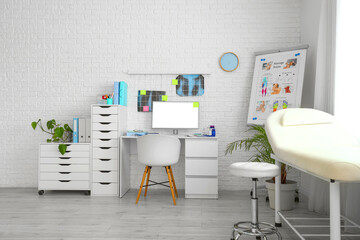 Interior of medical office with doctor's workplace and couch