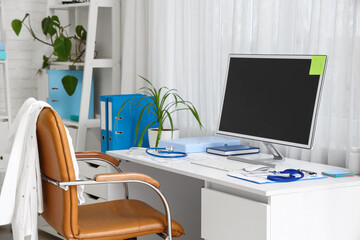 Doctor's workplace with blank computer monitor in medical office