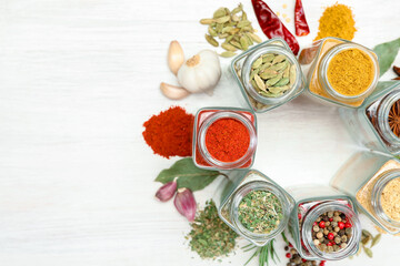 Different aromatic spices in jars on white table, flat lay. Space for text