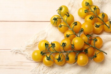 Ripe yellow cherry tomatoes on wooden table, flat lay. Space for text