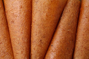 Delicious fruit leather rolls as background, top view
