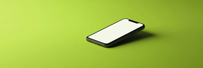 A black smartphone with a blank white screen rests on a lime green surface