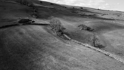 Aerial view of dry stone walls and stone built barns in typical Yorkshire Dales countryside terrain...