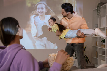 Family having fun during watching of movie at home
