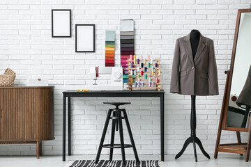 Interior of atelier with tailor's workplace, mirror and mannequin