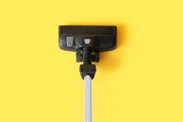 Brush of modern vacuum cleaner on yellow background