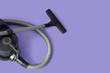 Modern vacuum cleaner on purple background