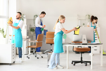 Team of janitors cleaning in office