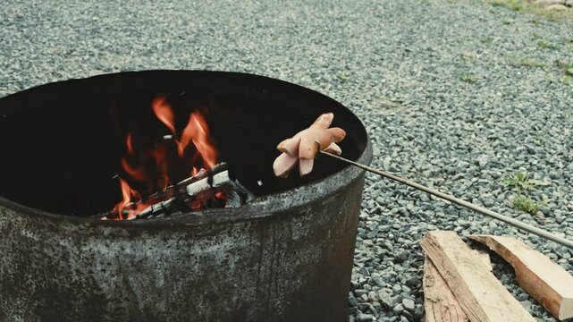 Ein Cervelat brutzelt &uuml;ber dem offenen Feuer, eingeritzt und aufgespie&szlig;t &ndash; der Rauch steigt auf, es duftet nach Holz und R&ouml;staromen. Ein echter Schweizer Grillmoment in der Natur.