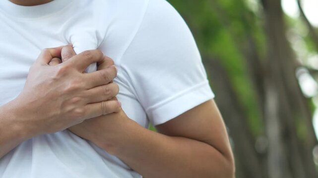 Men have chest pain. hand hold chest with heart attack symptoms, caused by heart disease, leak, dilatation, enlarged coronary heart, press on the chest with a painful expression.