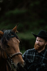 cowboy man with red beard in hat with horse close-up, friendship with animal
